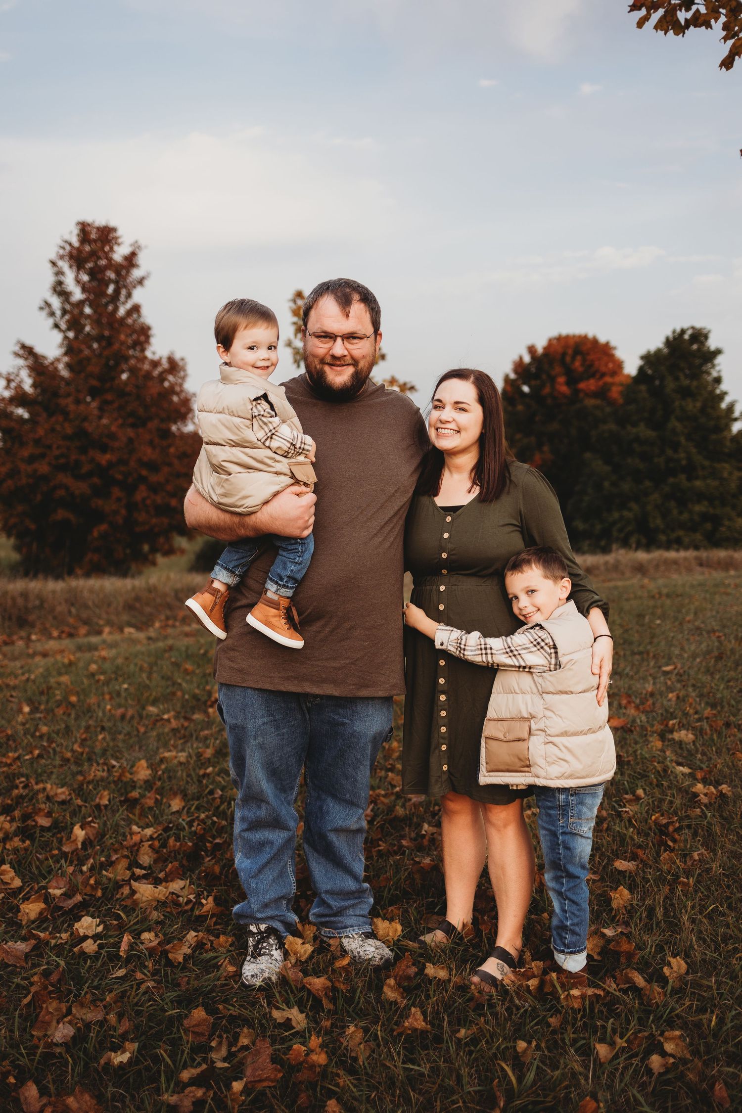 family of four posing smiling at the camera during fall minis