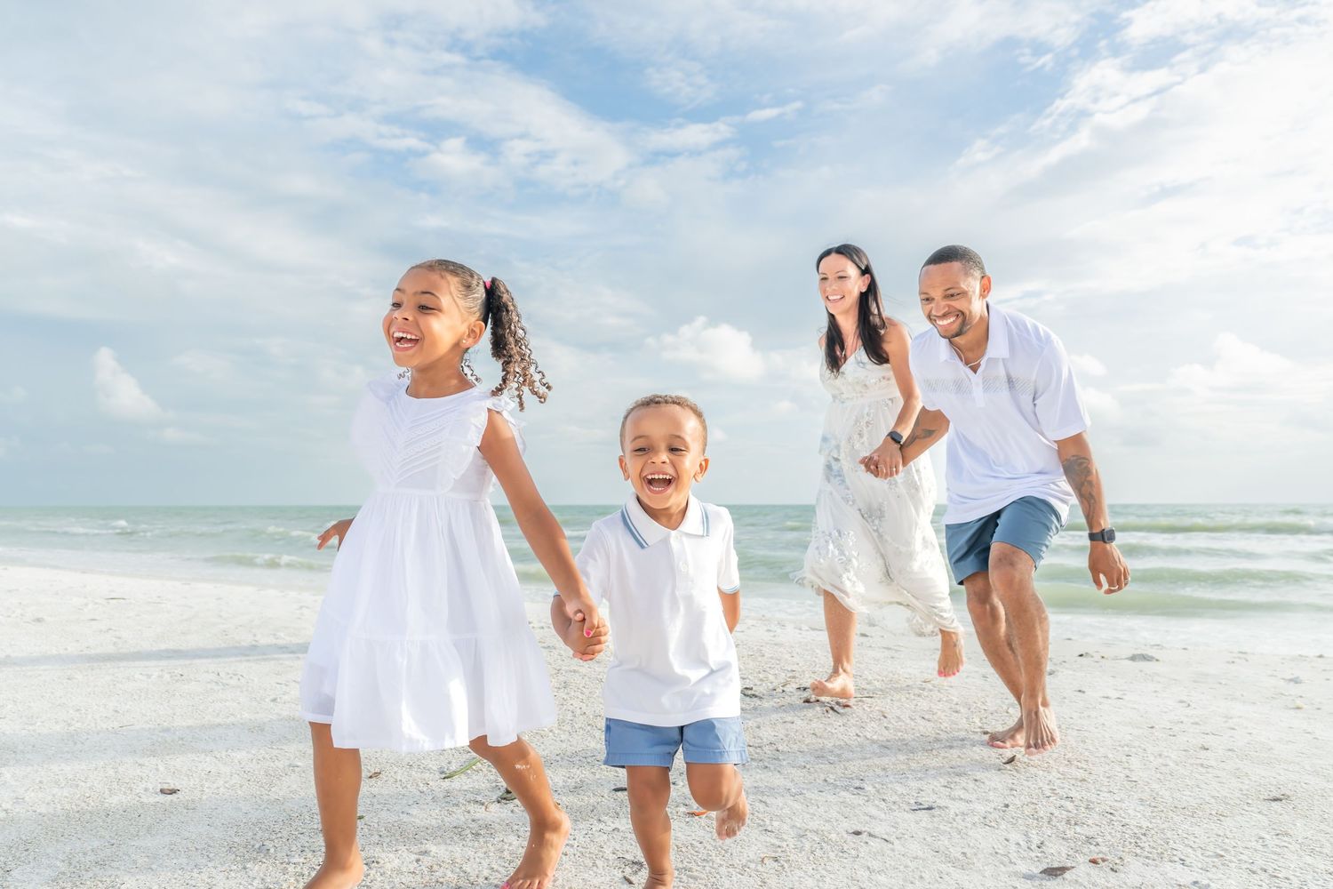 Family shares loving moment on rocky beach overlook during golden sunset.