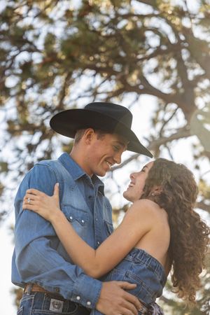 A romantic couple in western attire share tender moments in a series of four connected photos under sunlit trees.