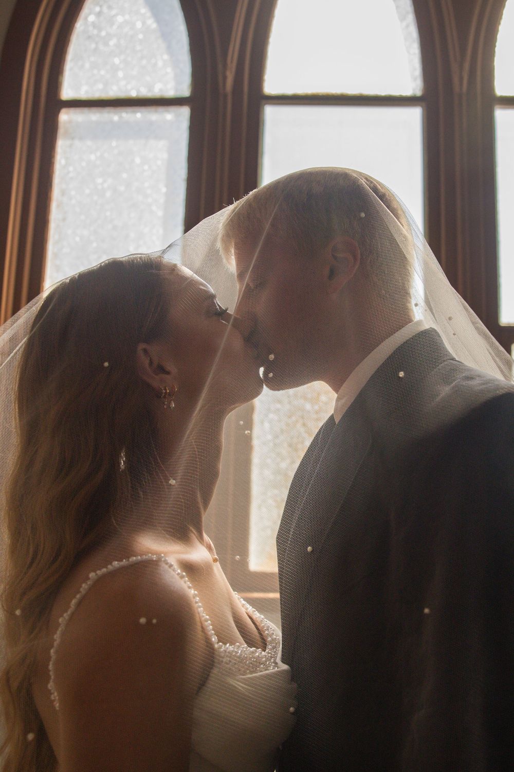 A romantic sequence of wedding photos showing a couple in silhouette against sunlit windows sharing intimate moments.