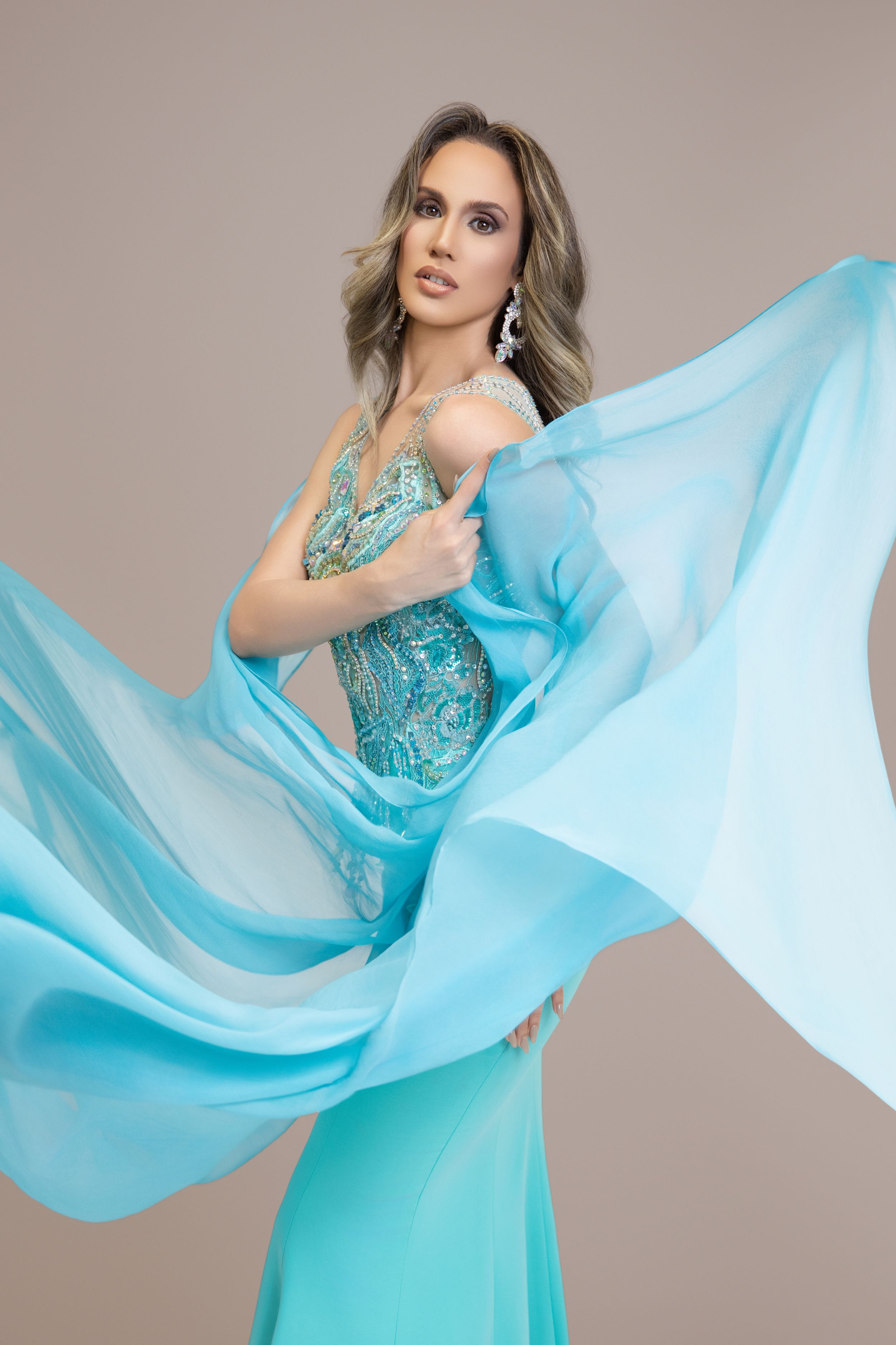 Fashion model in flowing turquoise gown with dramatic fabric movement. Photographer Jose JONAV Navarro at Miami Florida. Miss Universe Cuba.