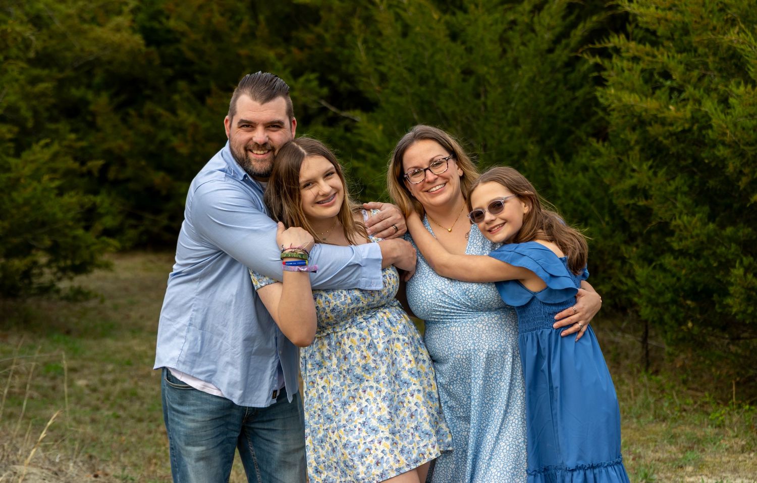Family of 4 wearing blue in the woods of their back yard. Salem and Gloucester County Family Photographer