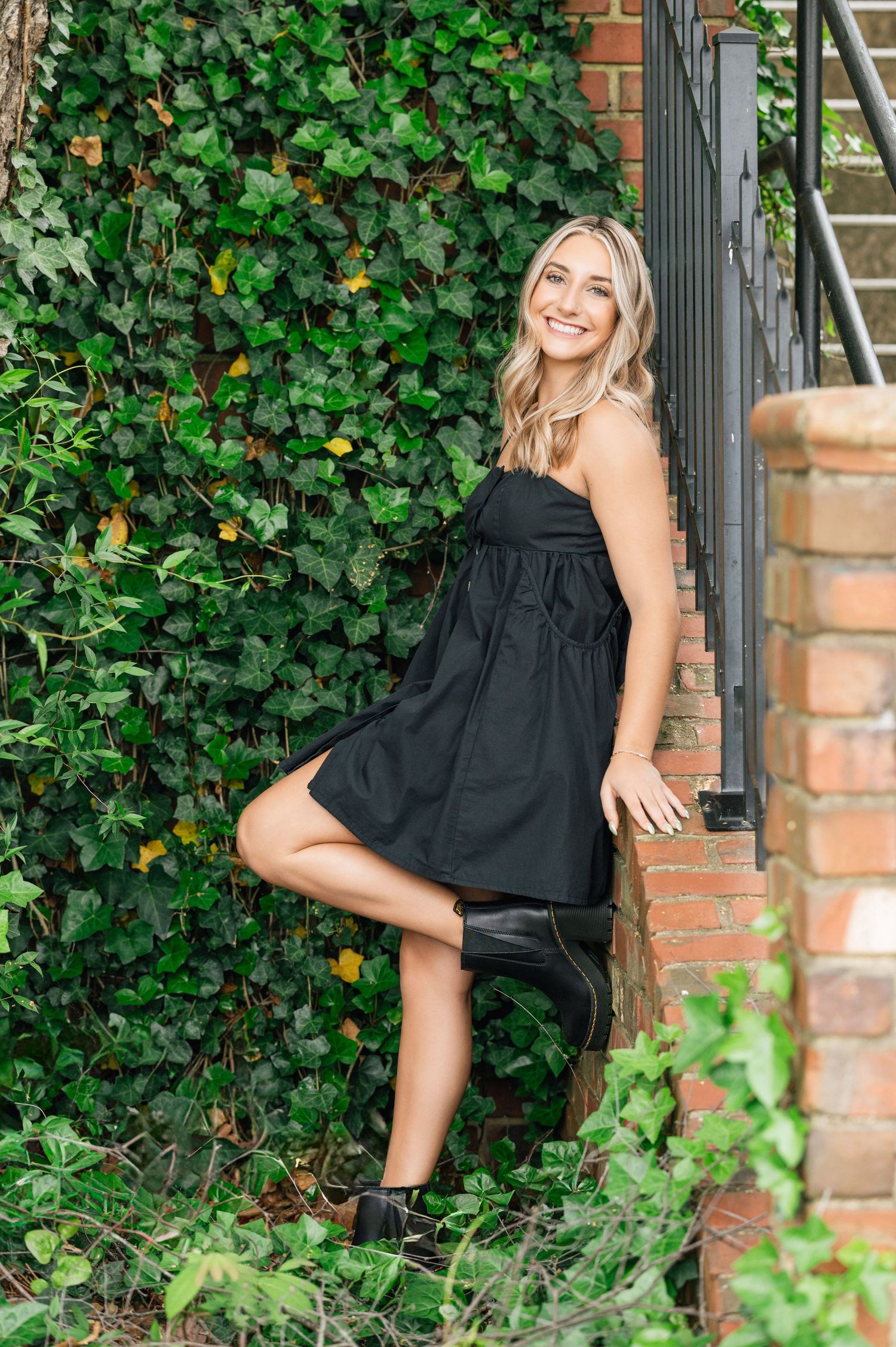 Autumn outdoor portrait session with warm orange foliage and brick wall backdrop.