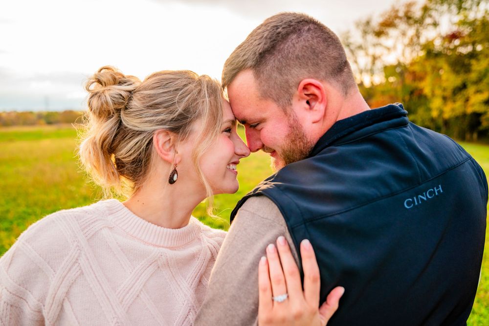 A couple shares tender moments in a series of autumn engagement photos with golden foliage in the background.