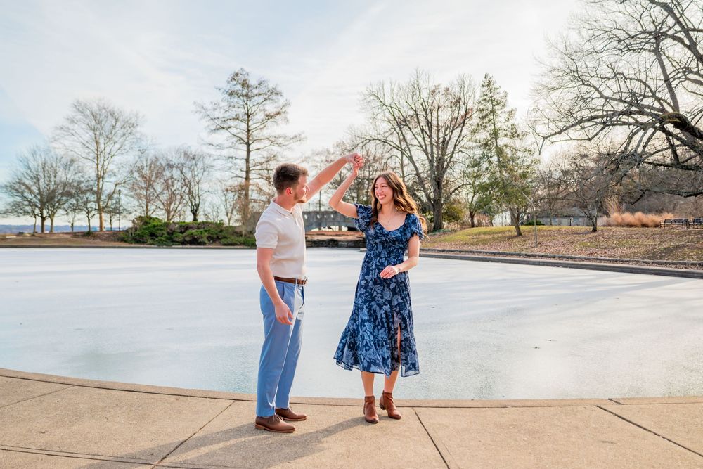 A couple stands together on a concrete pier overlooking a misty lake during a romantic photoshoot.