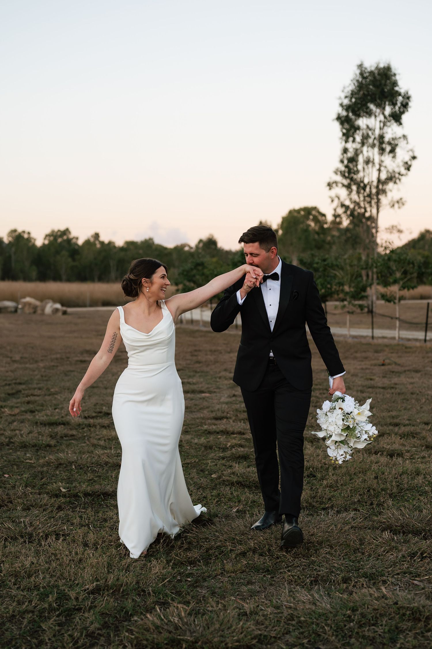 Couple shares romantic moments by an infinity pool overlooking a scenic tropical landscape at Yeppoon wedding venue.