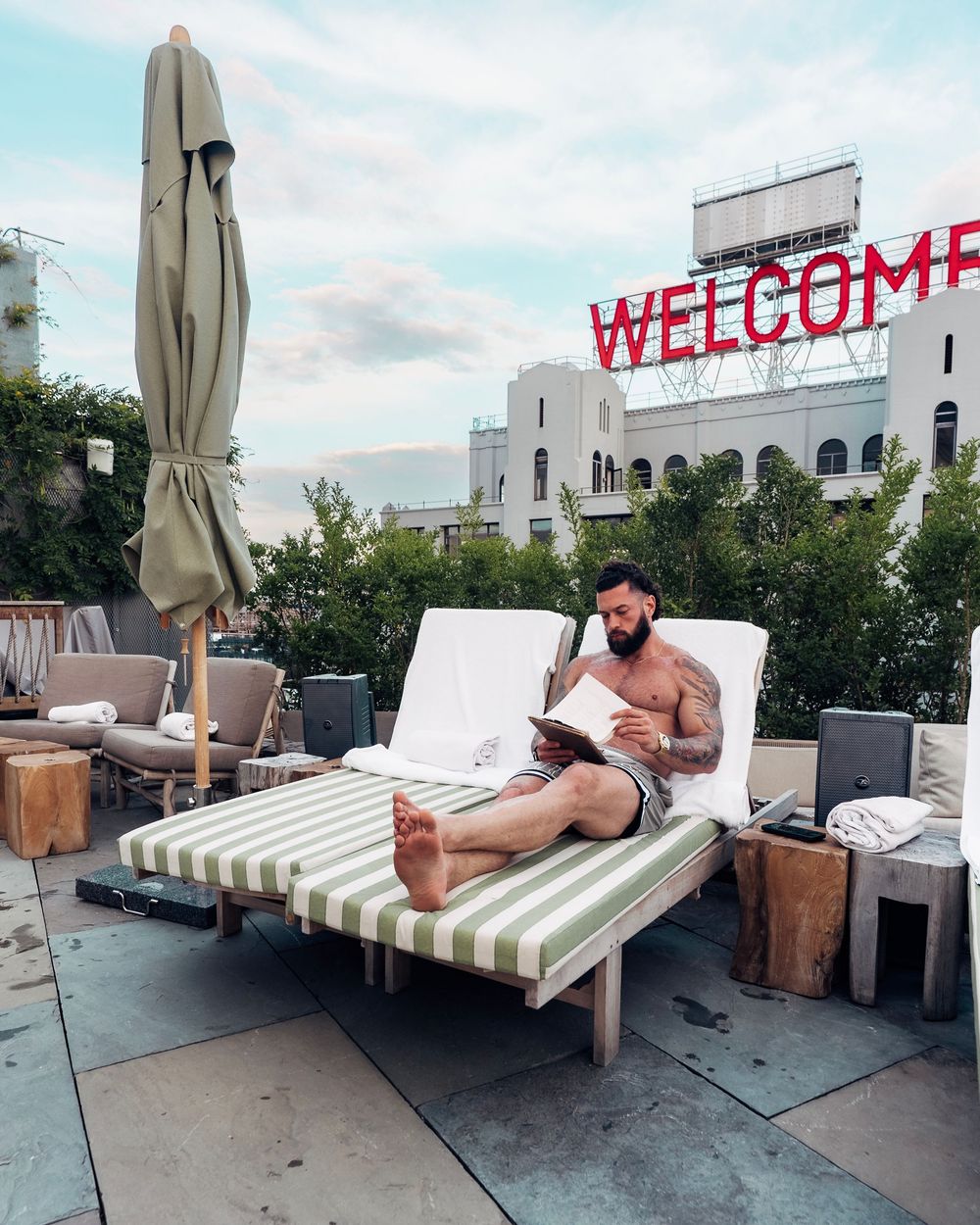 A sequence of photos showing someone lounging on an outdoor daybed on a rooftop terrace with urban buildings in view.