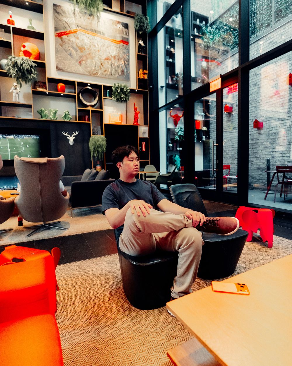 Modern lounge area with black and orange decor features comfortable seating and industrial-style brick walls and lighting.