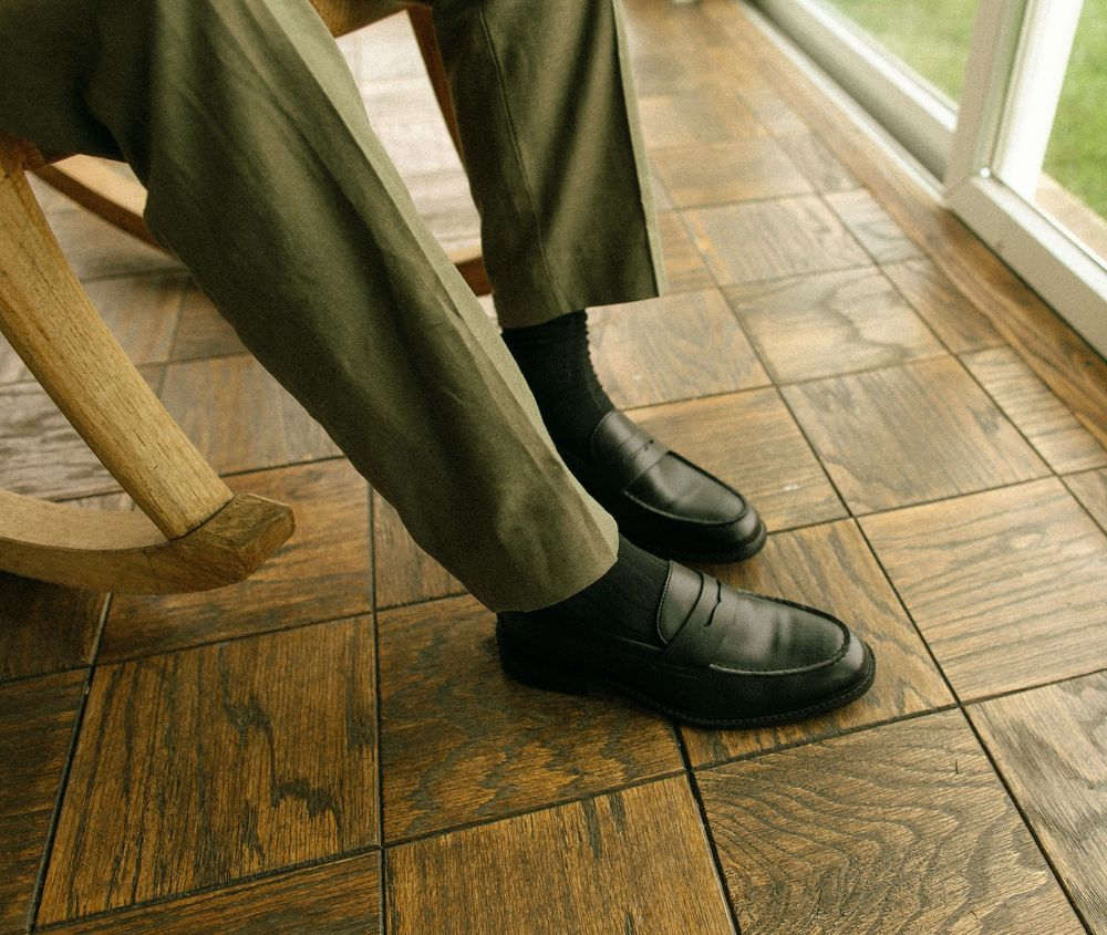 Close-up sequence of formal dress shoes on wooden floor.