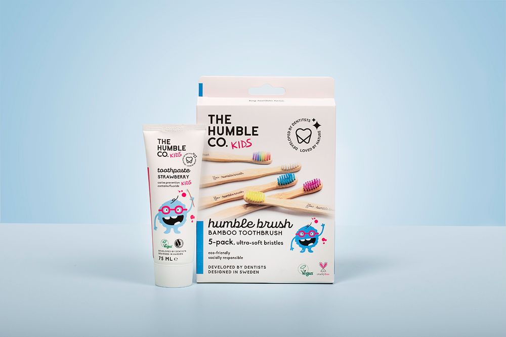 Dental hygiene product packaging displayed on light blue background.