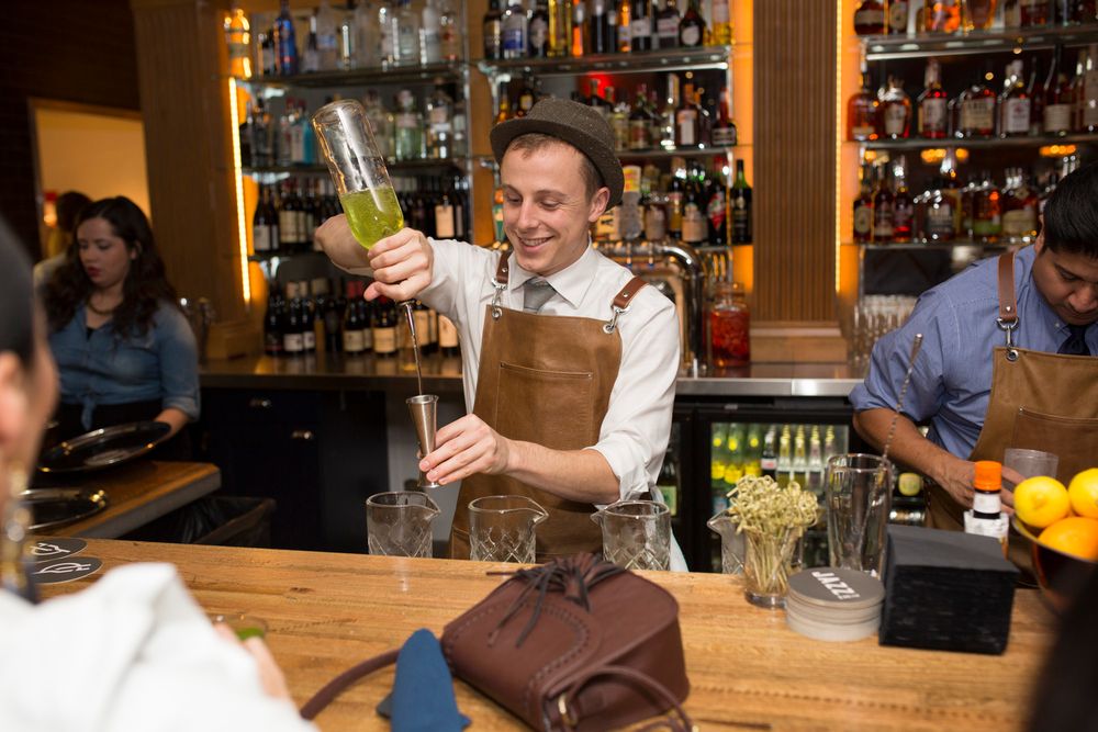 Behind the bar view showing bottles of spirits and glassware in restaurant setting.