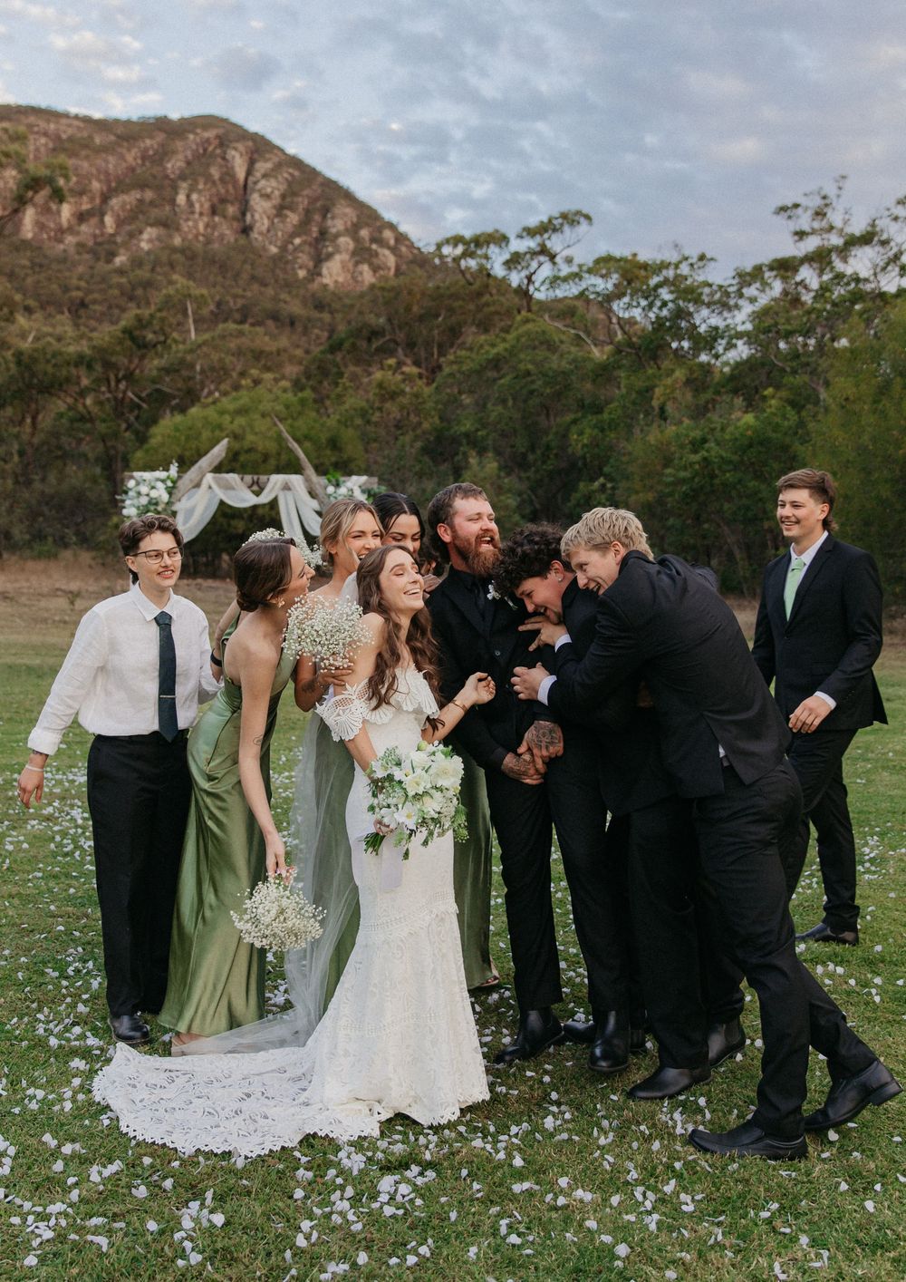 Wedding party celebrating with bride and groom at outdoor mountain ceremony.