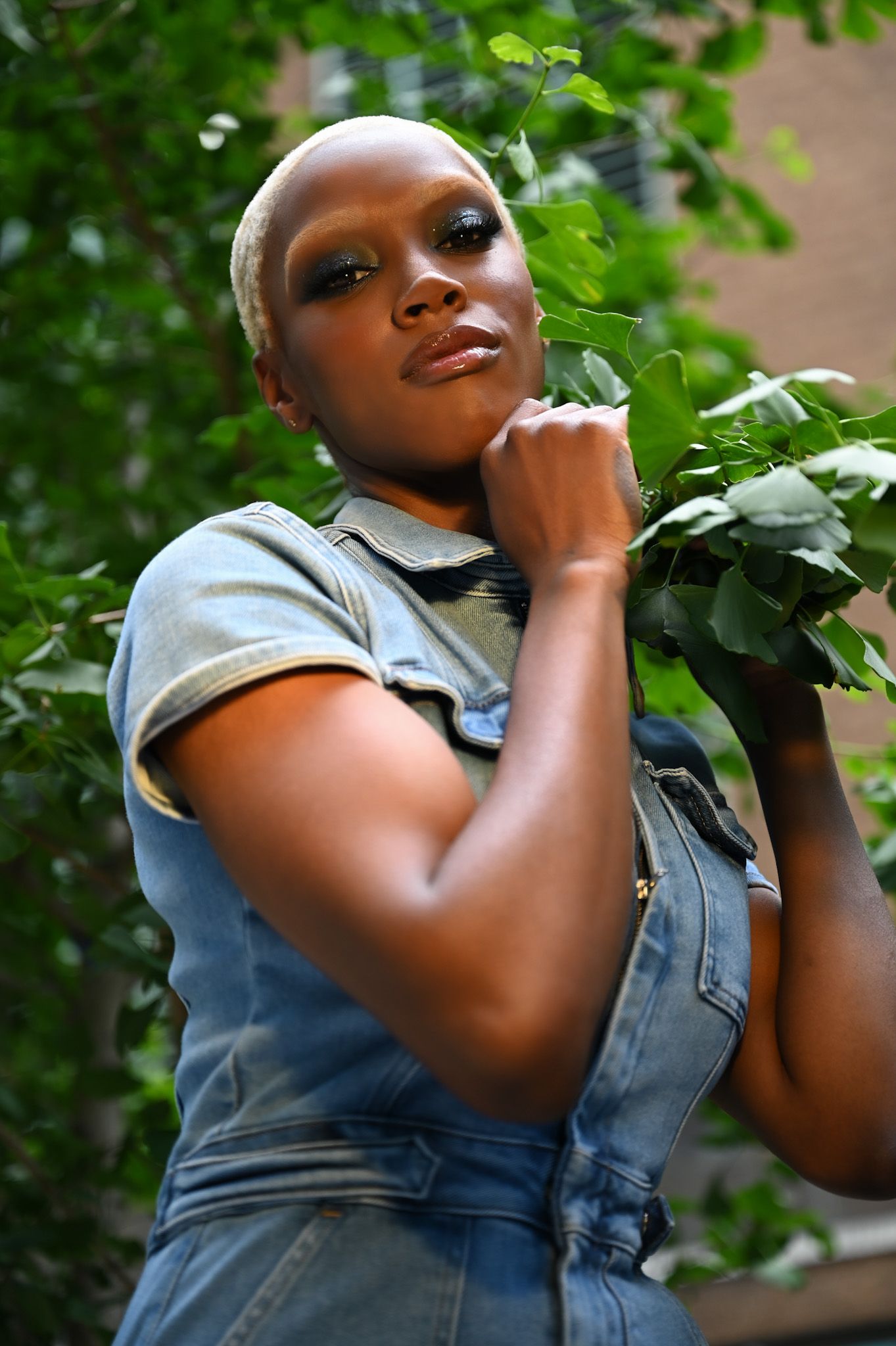 A profile view shows statement hoop earrings and an updo hairstyle against an urban backdrop.