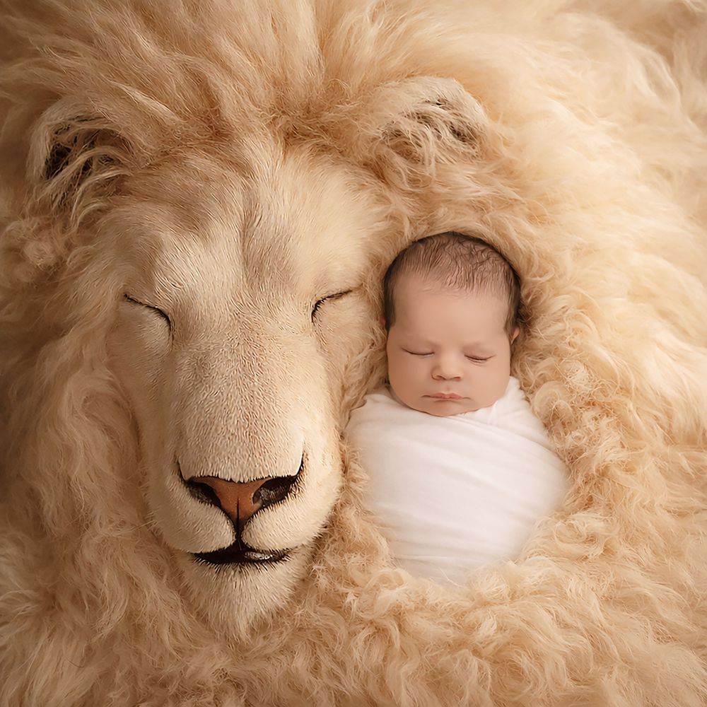 Creative newborn photography using soft cream-colored fur as a cozy backdrop.