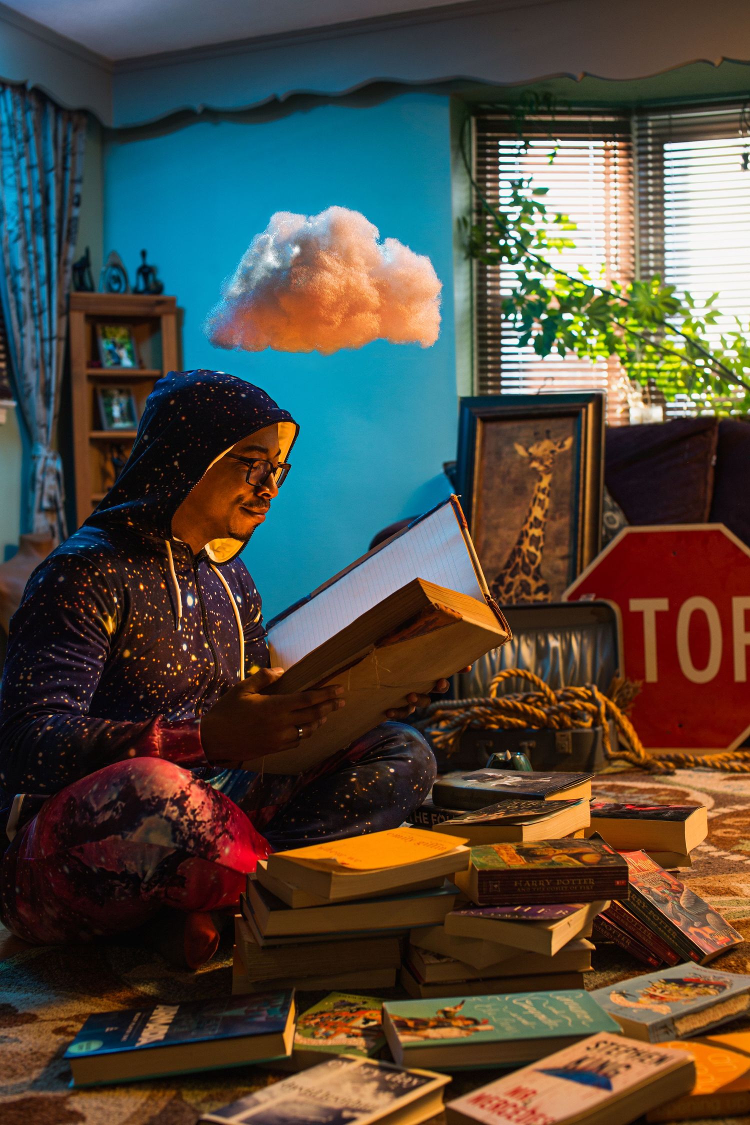 Person reading a book while sitting on the floor surrounded by books with a cloud above their head.
