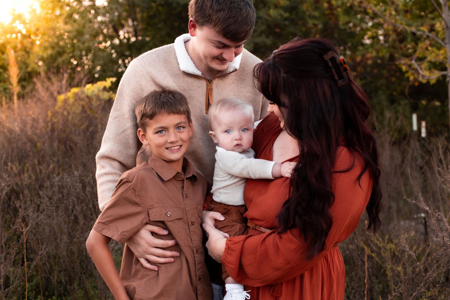 Family sharing intimate moment outdoors during golden hour sunset.