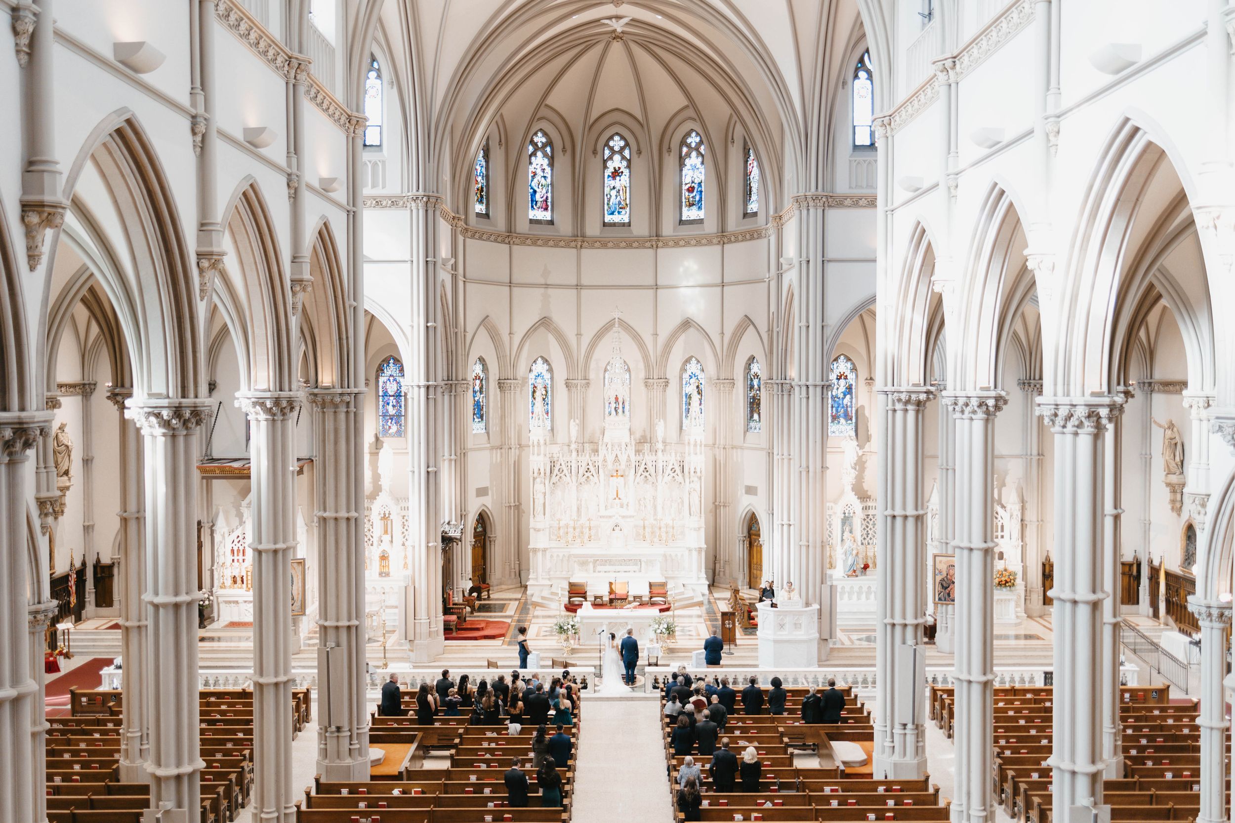 Couple exchanging vows in church captured in wide angle.