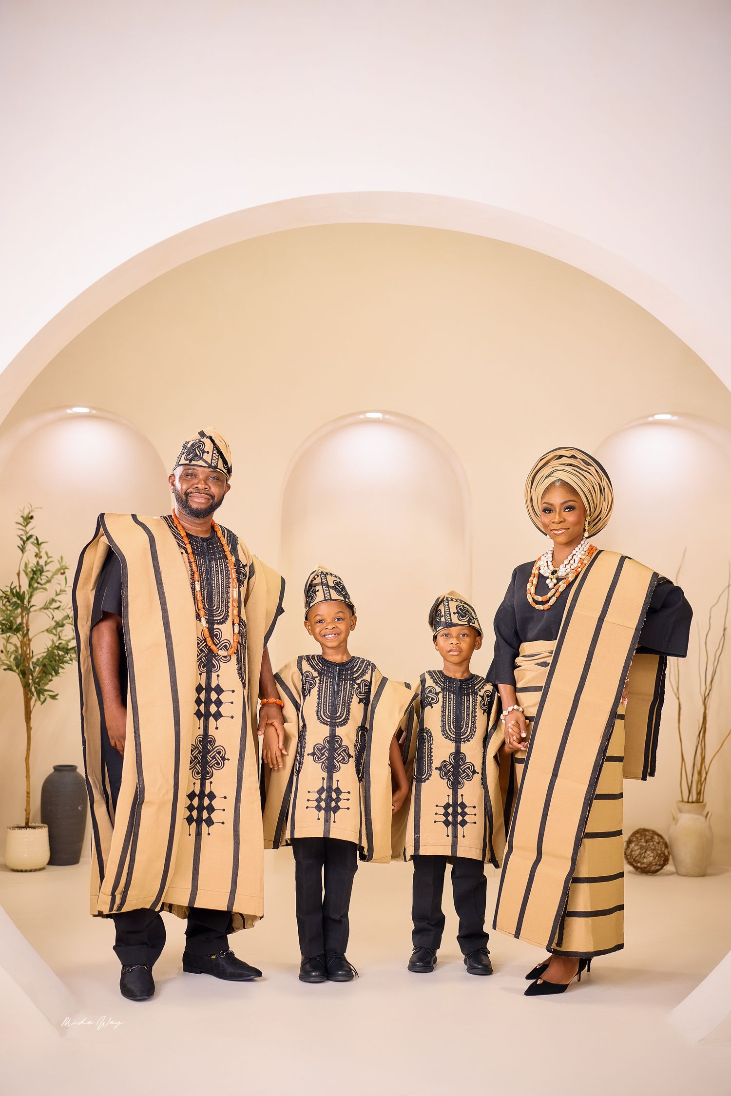 A series of four connected photos showing a line of people wearing coordinated beige and black traditional outfits.