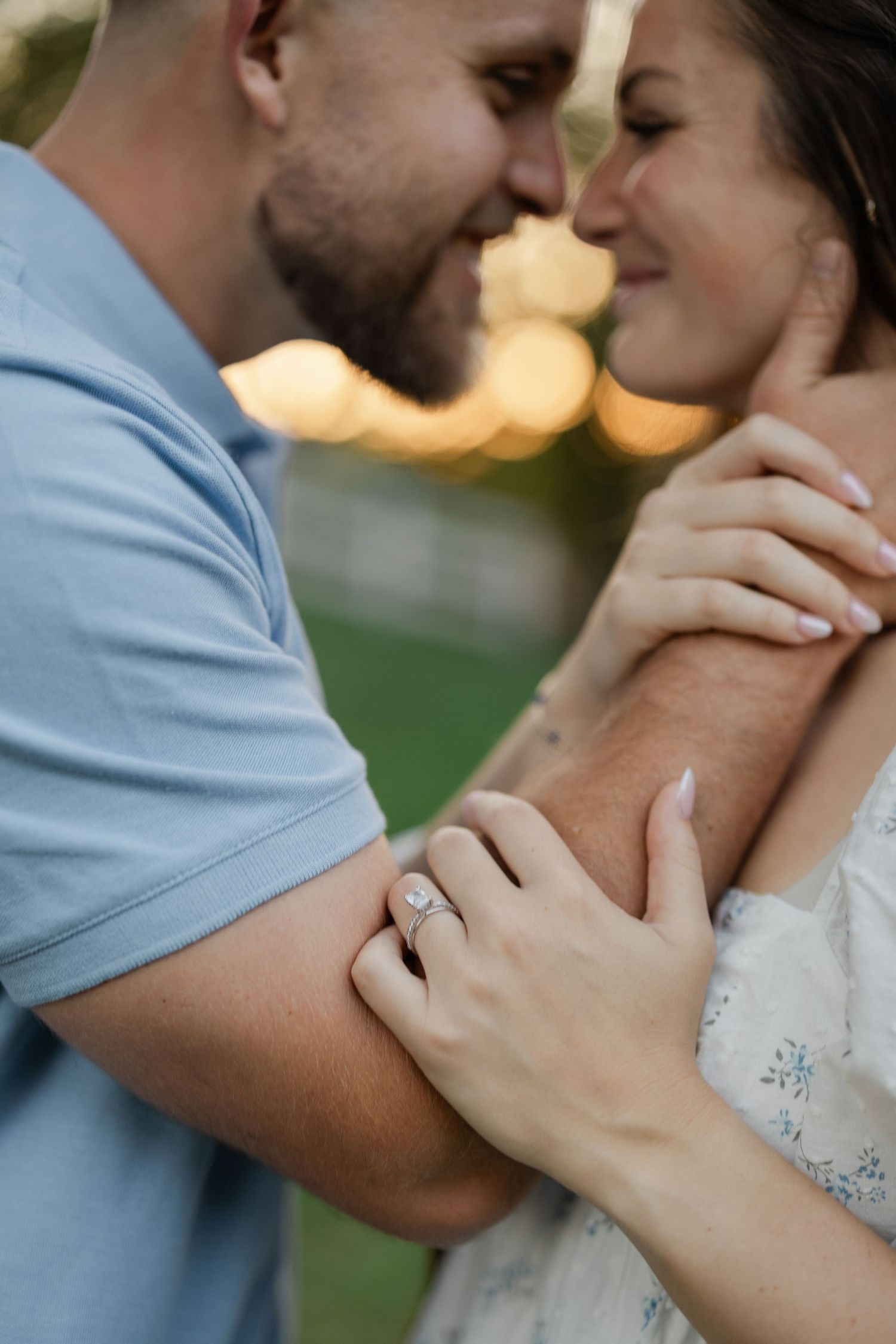 A romantic embrace between a couple wearing white against an elegant white wall with decorative molding.