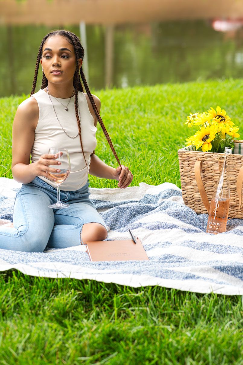 Young woman enjoying a peaceful picnic surrounded by nature.