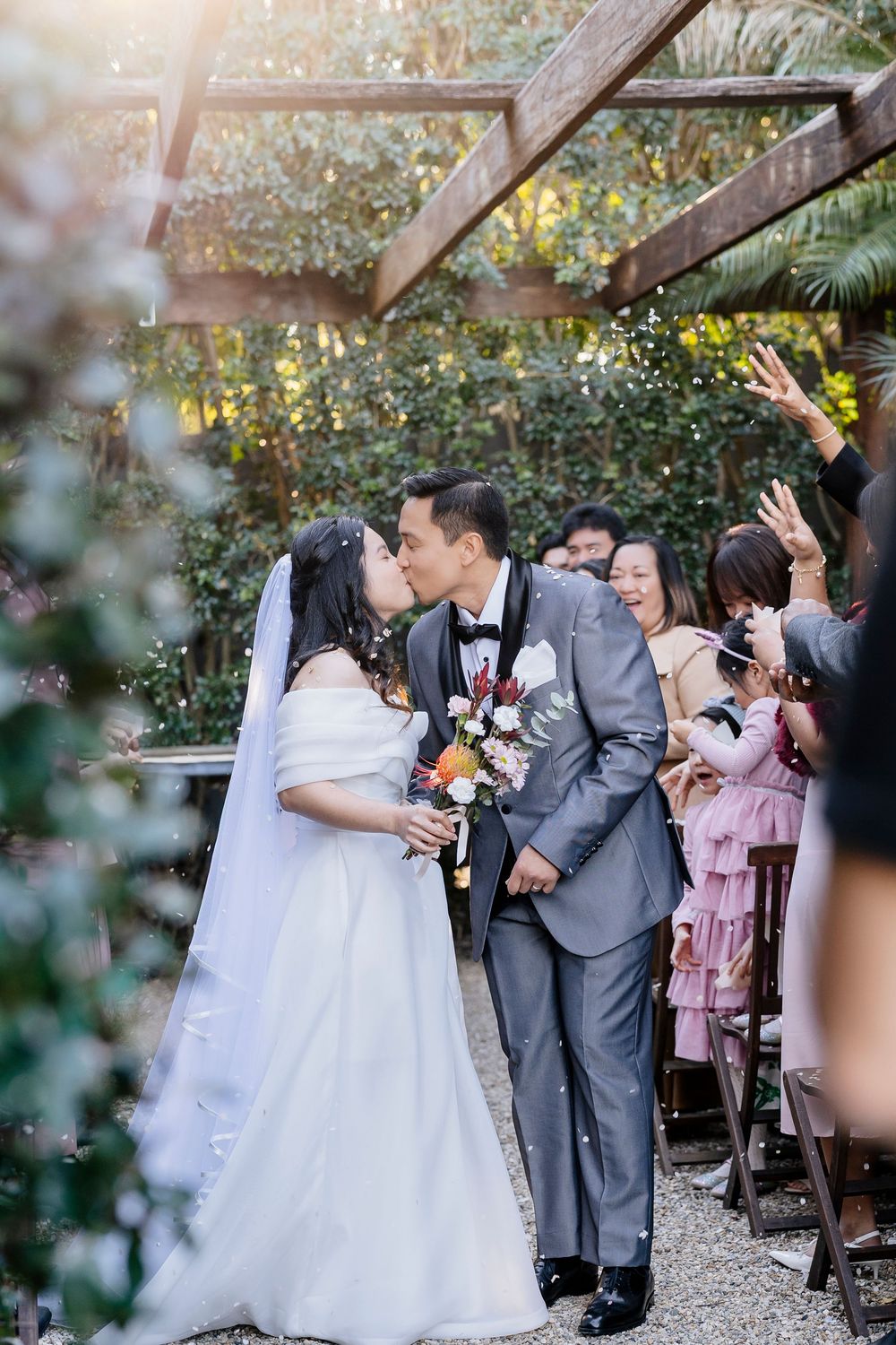 A wedding celebration sequence showing joyful moments between newlyweds and guests in an outdoor garden setting.