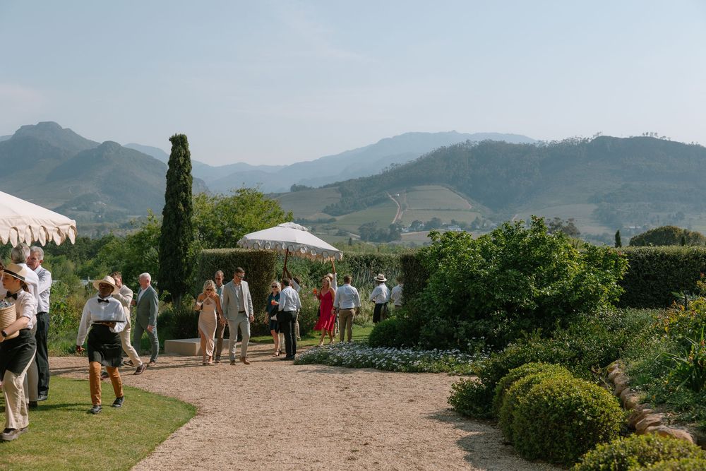 Panoramic view of a scenic mountain landscape with tents and people gathered for an outdoor event.