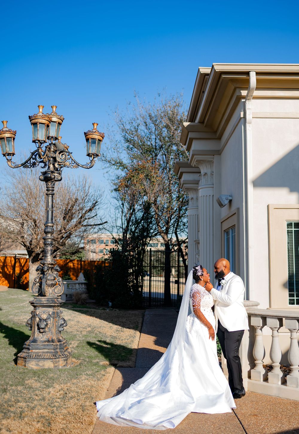 A romantic wedding photo session on a terrace with white columns and ornate architectural details.