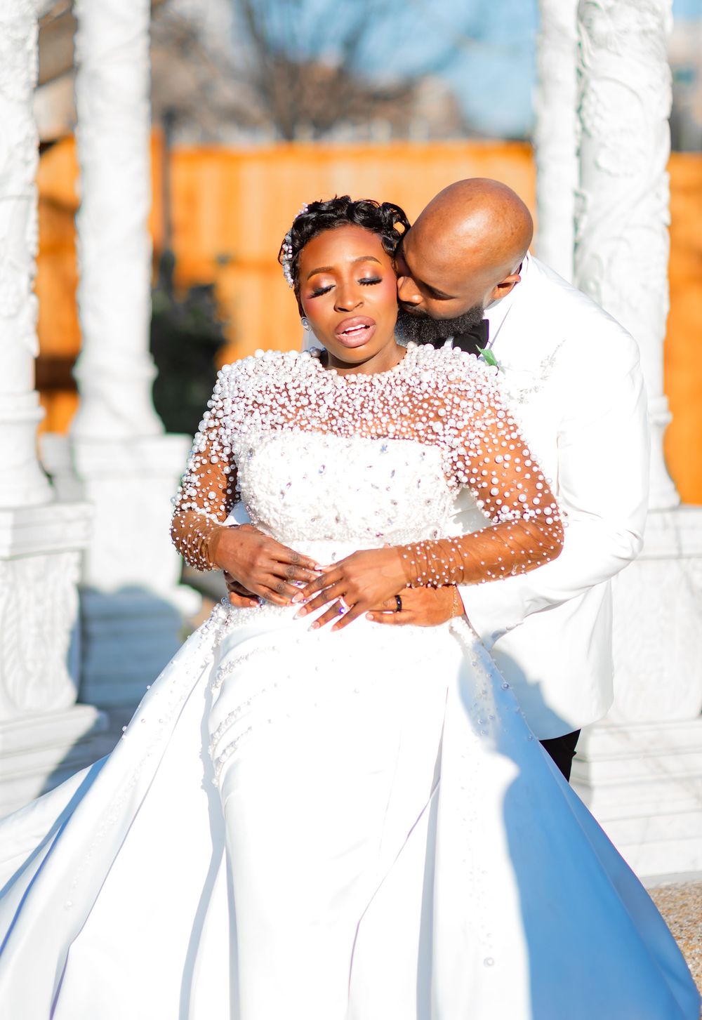 A loving family moment captured in a series of white-themed outdoor photos against white pillars on a sunny day.