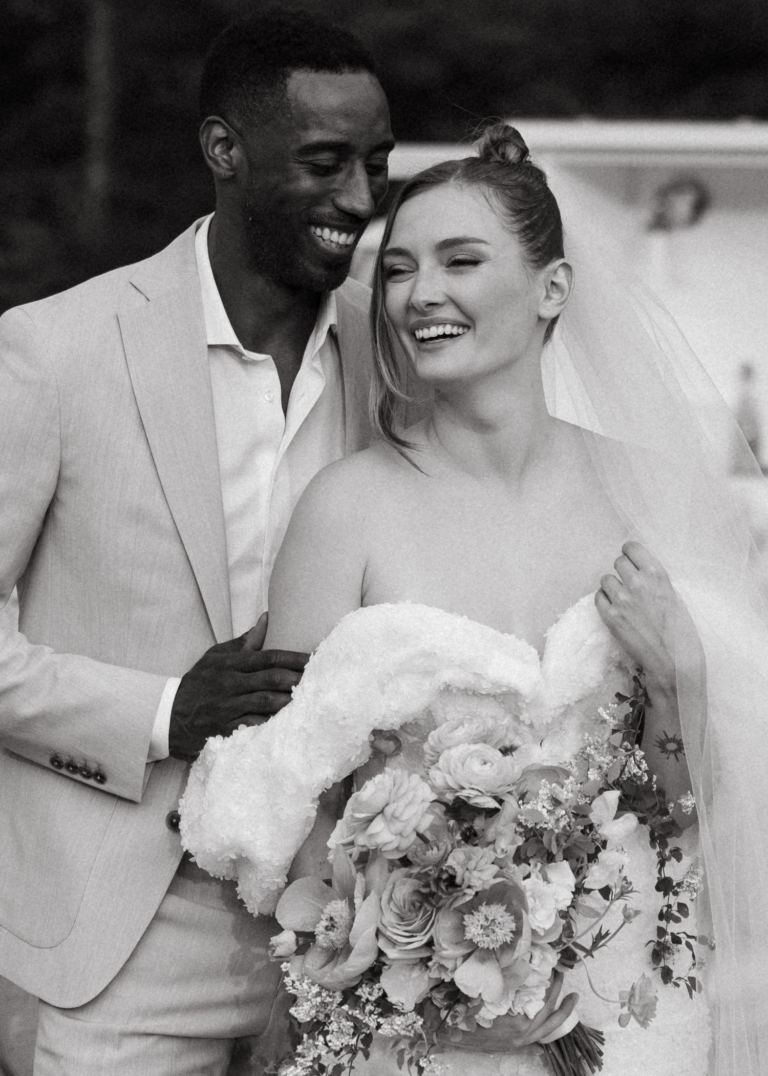 Black and white wedding photos show joyful couple sharing intimate moments with elegant bouquet of white flowers.