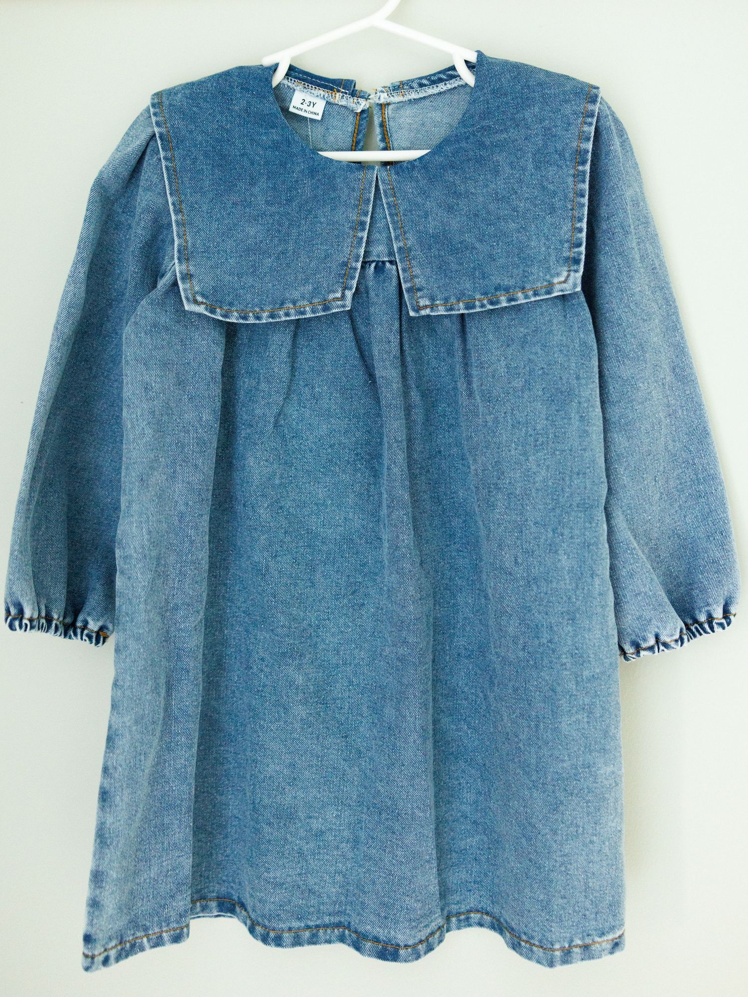 Vintage denim dress with large collar and elastic cuffs features a loose-fitting smock style design.