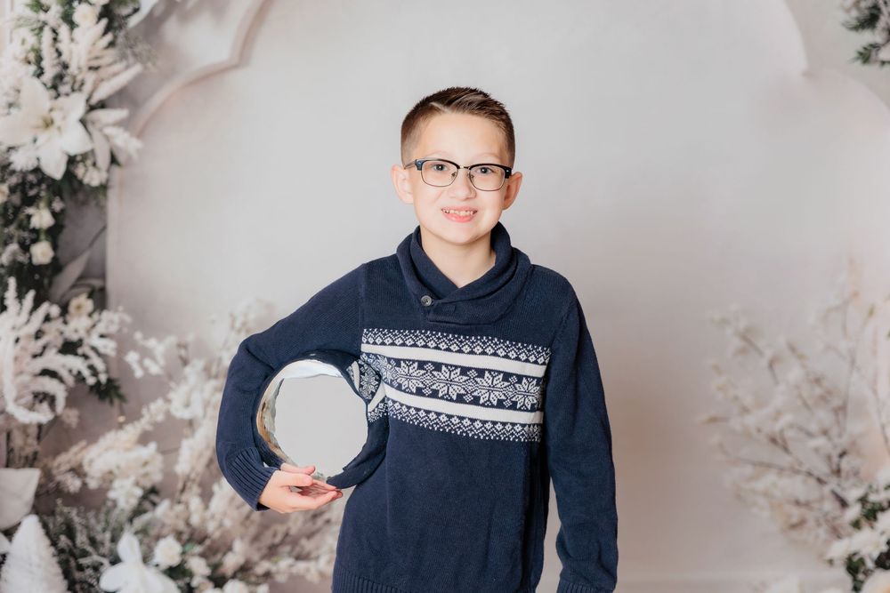 A series of four winter-themed studio portraits with silver ornaments and soft floral decor in the background. Clayton NJ Photo Studio