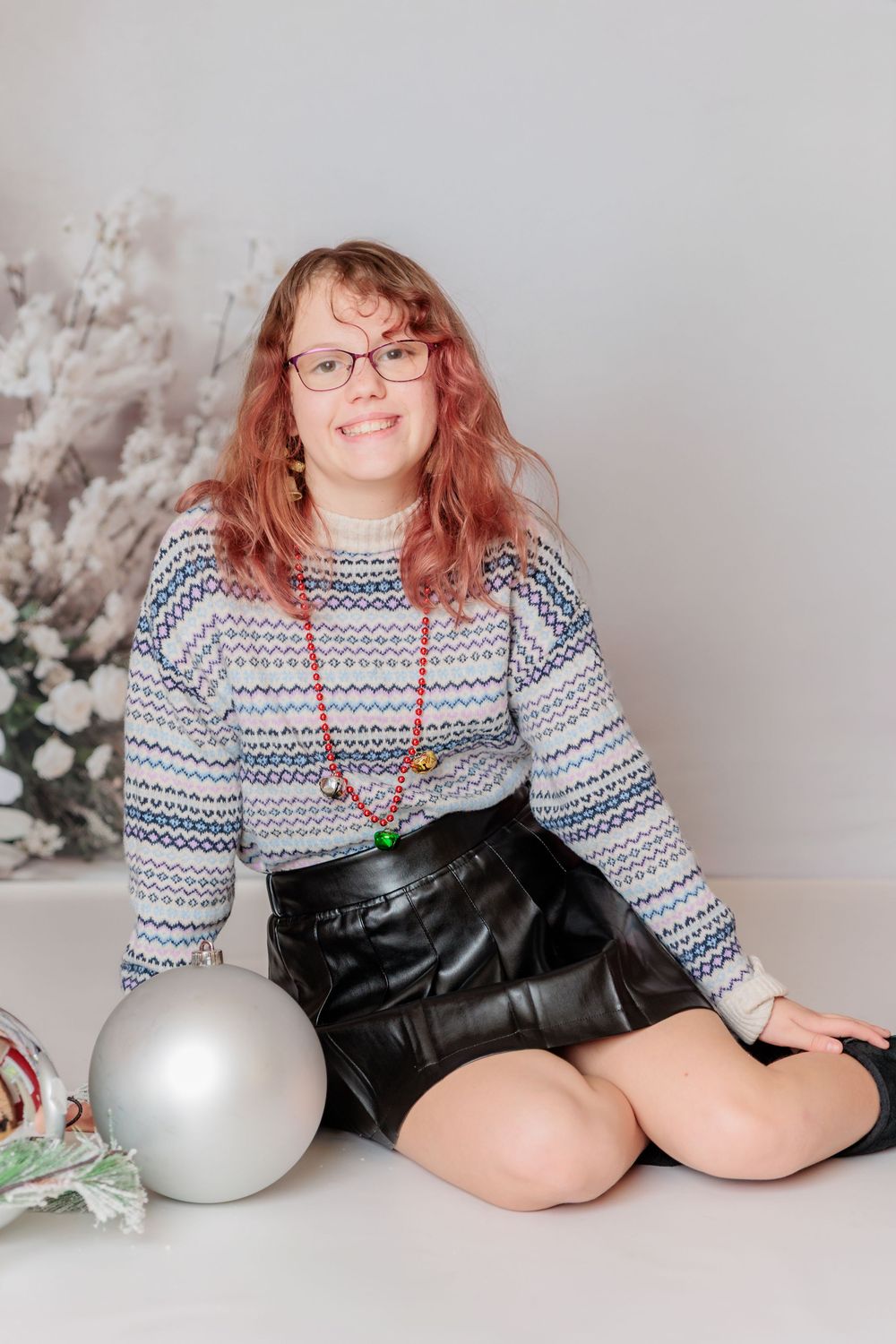 A holiday portrait session featuring white Christmas trees and silver balloons in a studio setting. Clayton NJ Photo Studio