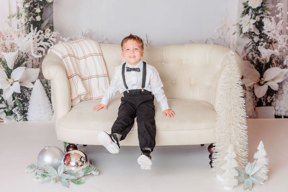 Cozy winter photo setup with white pillows, plush toys, and decorative trees in a studio setting. Clayton NJ Photo Studio