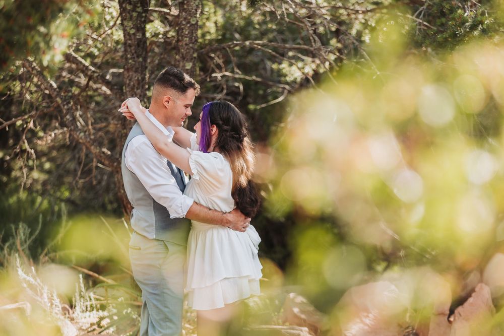 A romantic outdoor engagement photo session in a sunlit garden with natural bokeh effects and soft lighting.