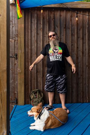 Dogs relax on a blue wooden deck while someone stands nearby.