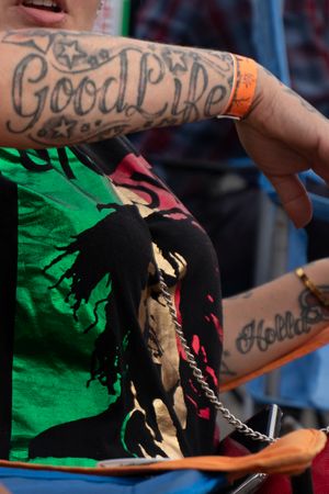 A series of four cropped images showing tattooed hands holding a torn green and black fabric.