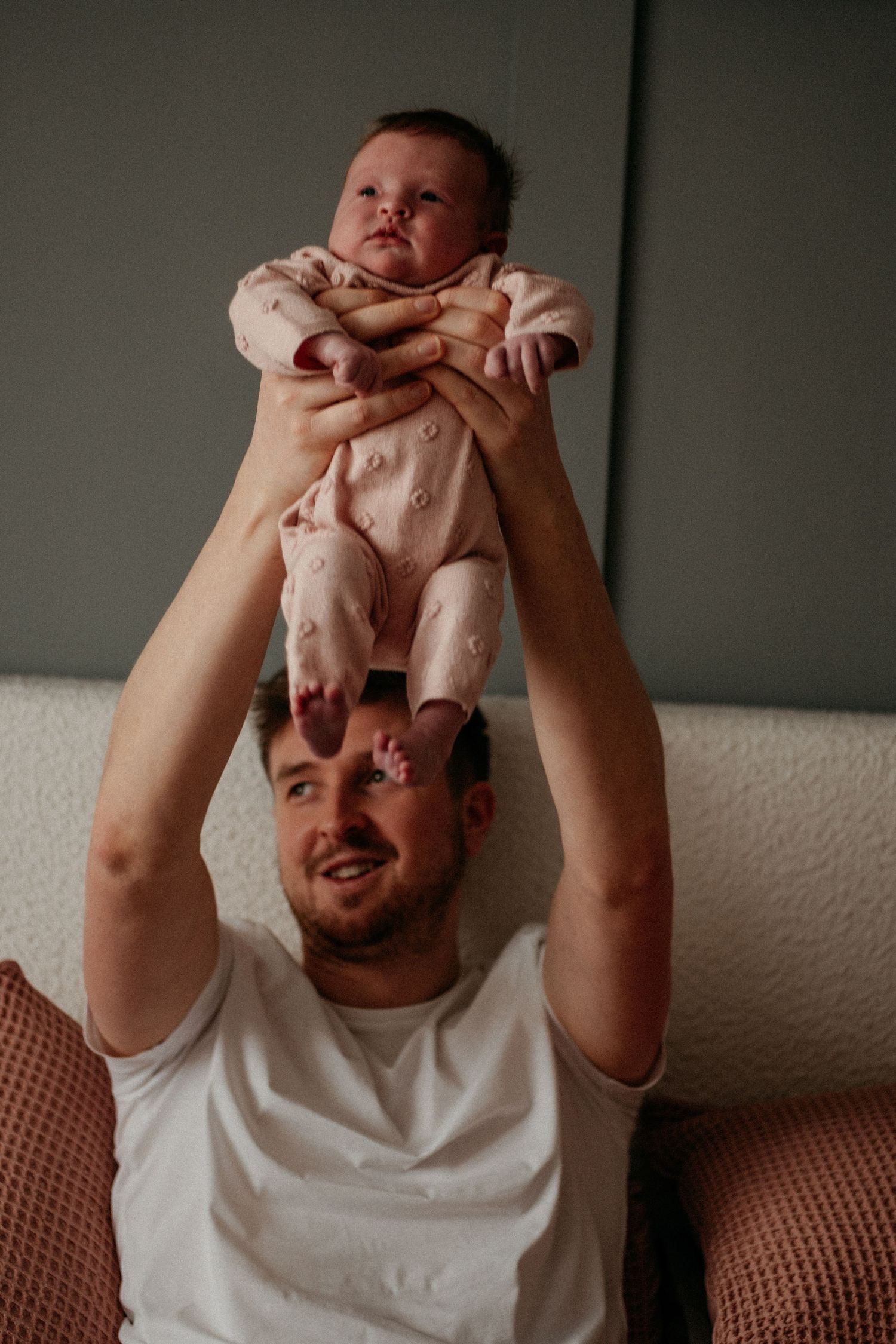 Father lifting up his newborn at a newborn photo session in Longbenton