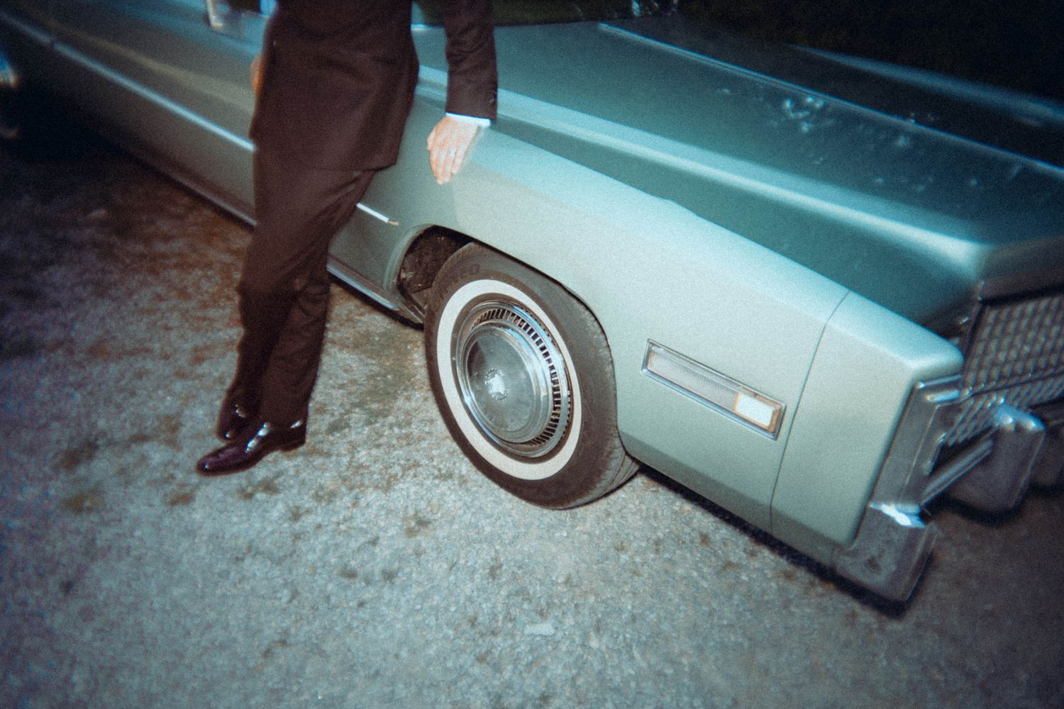 Vintage Cadillac night shot with groom’s legs in frame – cinematic Las Vegas elopement vibe, alternative wedding photography style.