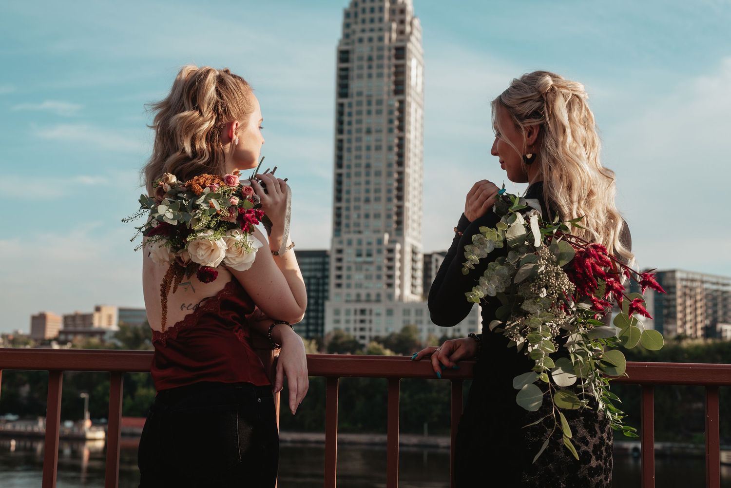 A romantic couple shares a tender moment on a rooftop with the city skyline and sunset in the background.