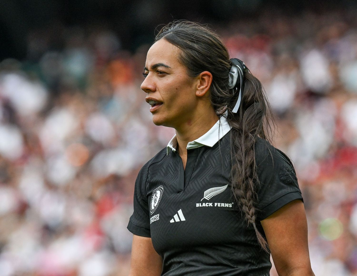 Rugby player in black All Blacks uniform runs with the ball during a match against England at Twickenham Stadium.