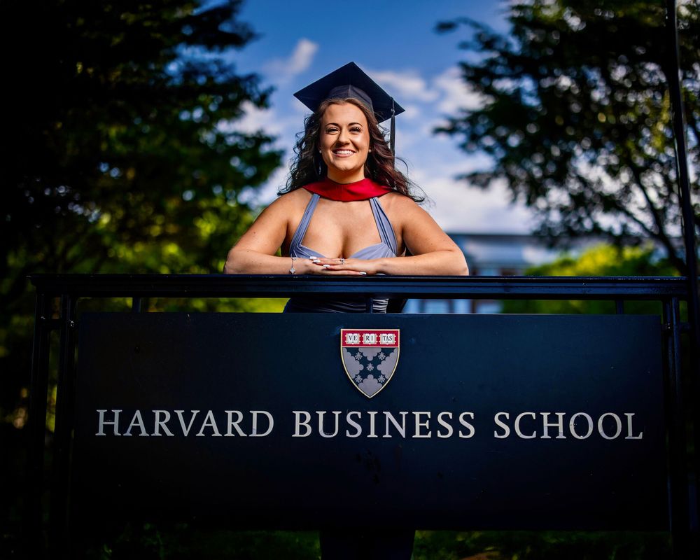 Graduation portraits at Harvard Business School campus with dramatic lighting and scenic views of the campus grounds.
