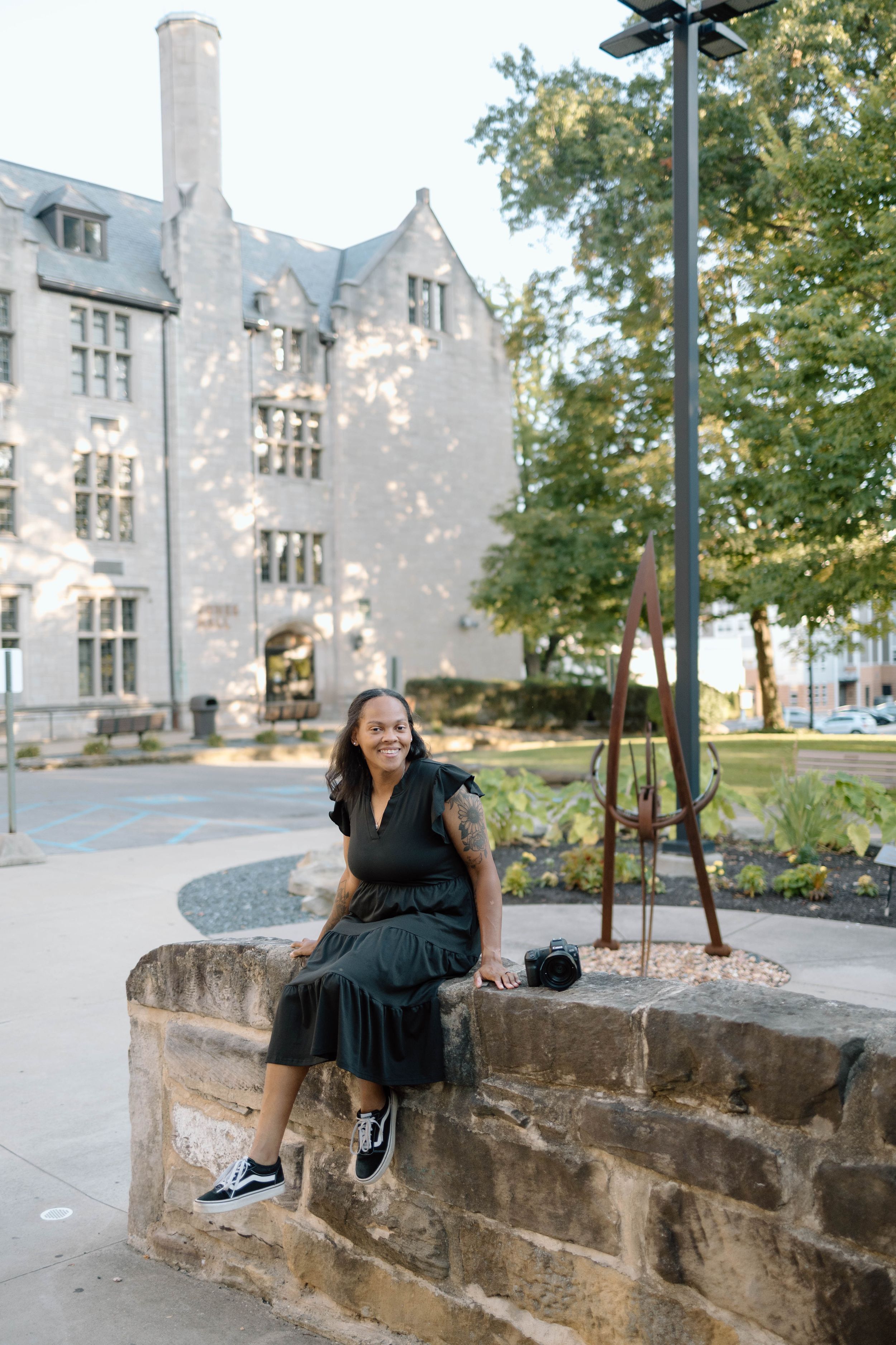 Portrait session on stone wall with gothic architecture in background.