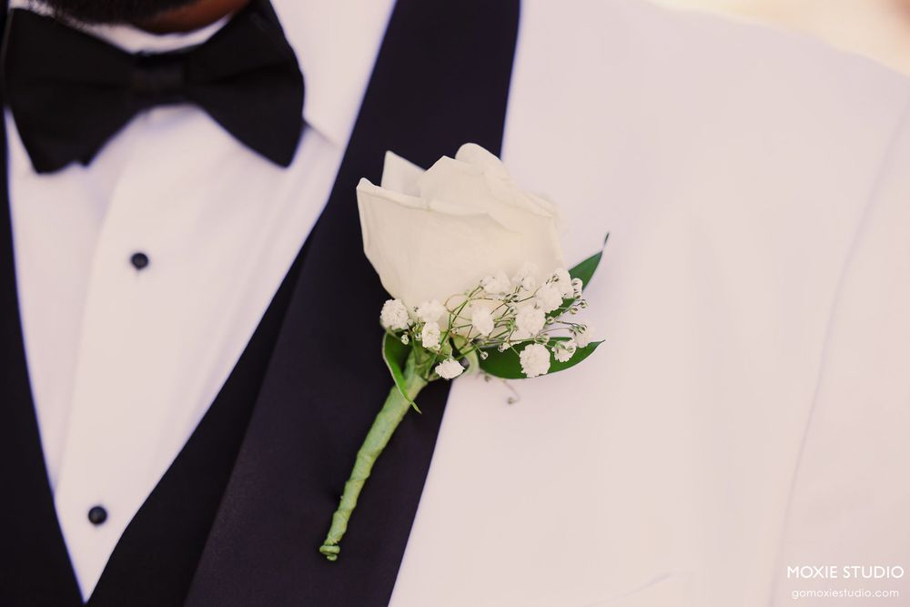Close-up details of formal black bow ties and white boutonnieres at an elegant wedding.