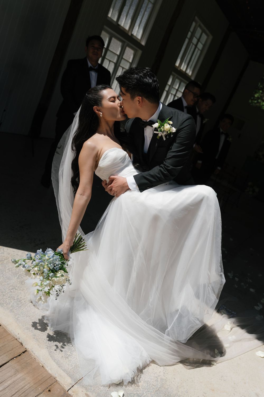 Romantic wedding couple sharing intimate kisses in a series of black and white portraits with flowing white dress.