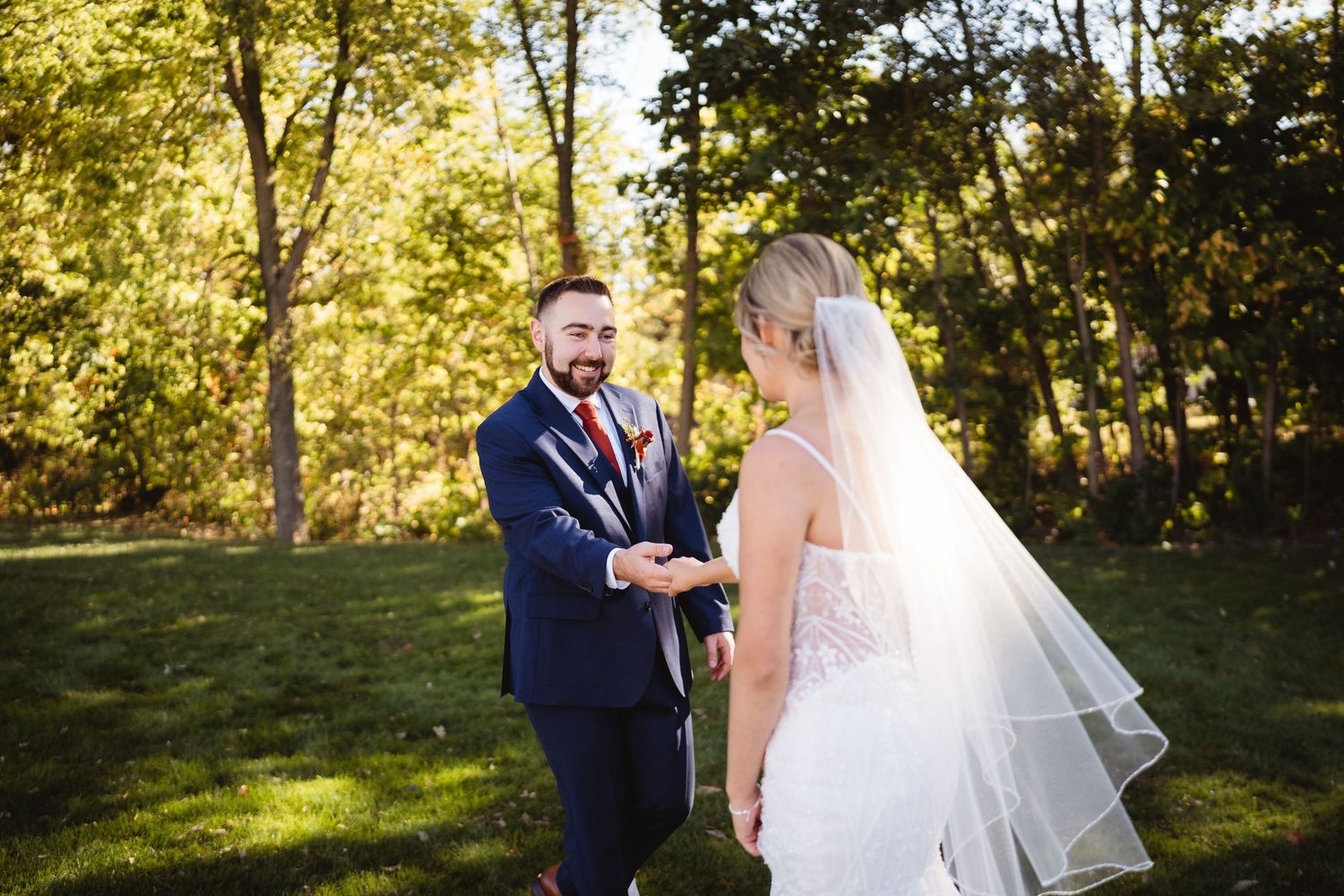A couple in wedding attire shares romantic moments in a sunlit outdoor setting during golden hour.