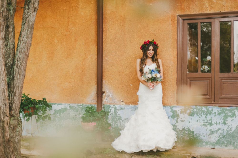 Bride standing in front of a yellow colonial house in Colombia.