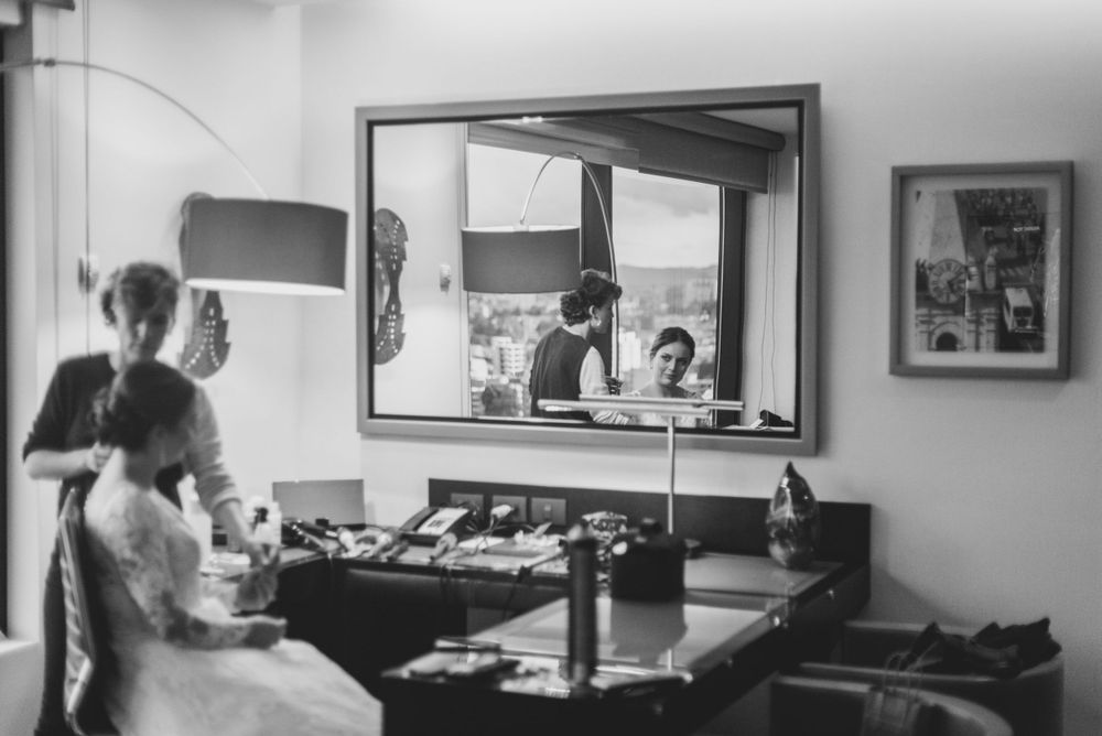 Bride looking at herself in the mirror getting ready for her wedding.