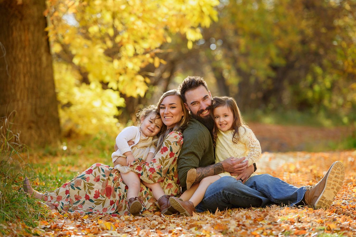 Professional Family Photographer in Blackfoot Idaho with young famiy in fall leaves