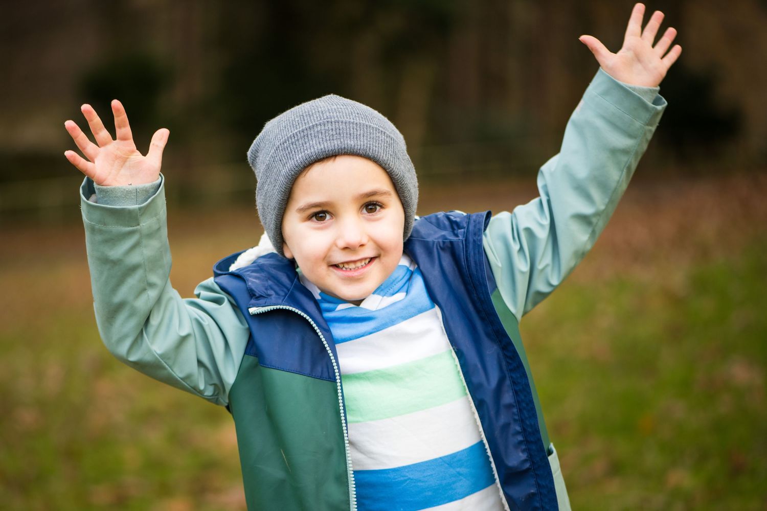 5 year old boy with his arms in the air during an autumn photoshoot