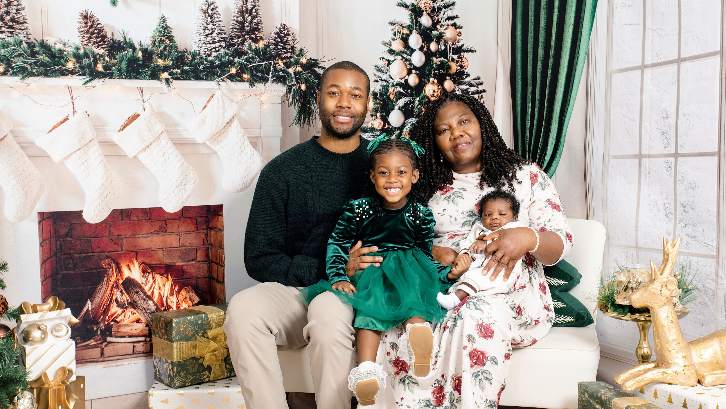 Family Christmas photo session in a living room with green curtains and holiday decorations.